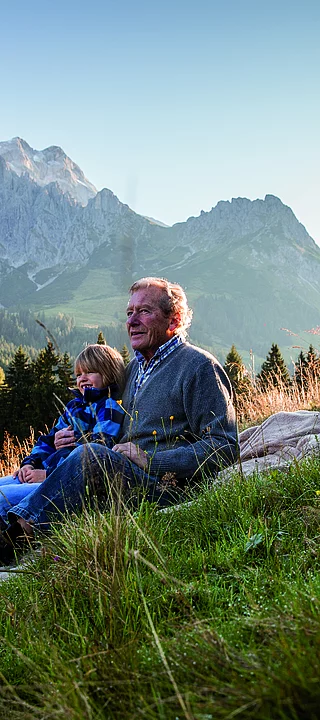 Übergossene Alm - Opa mit Enkel auf der Wiese Sommer Sonnenuntergang