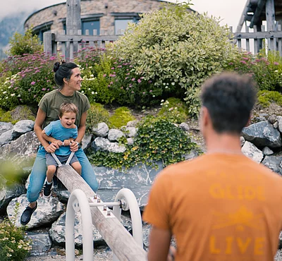 Übergossene Alm - Outdoor Almspielplatz Familie mit Kind beim Wippen