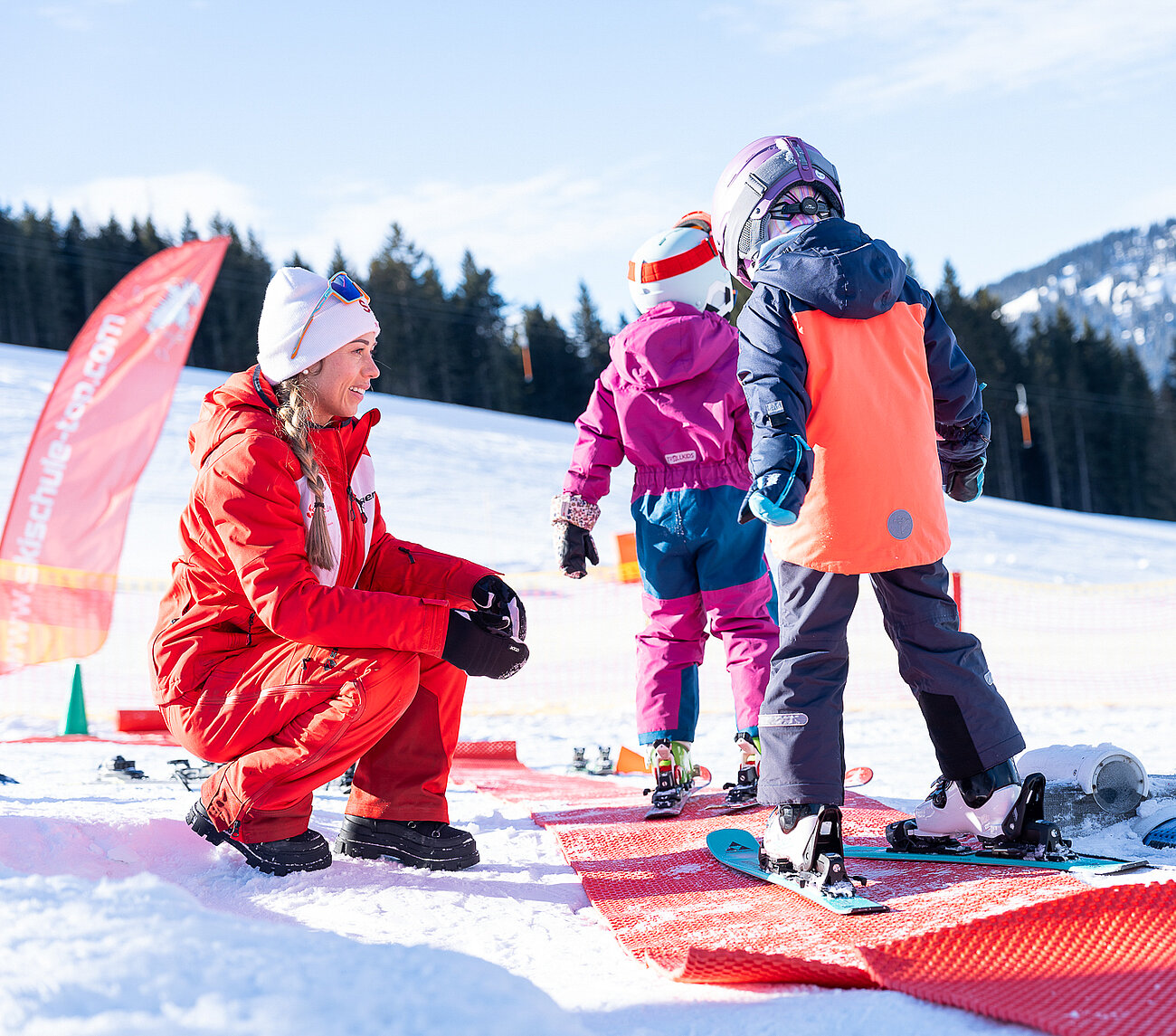 Kinder mit Skilehrerin am Kinder Trainingsgelände 