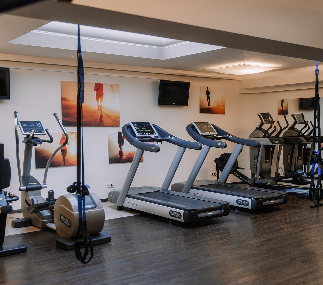Cardiobereich mit Laufbändern, Crosstrainer und Fahrrad im Fitnessraum des Hotels