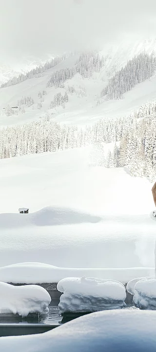 Übergossene Alm - Frau im außen Saunabereich Winter