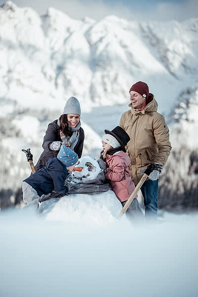 Übergossene Alm - Familie beim Spielen im Schnee