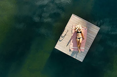 Übergossene Alm - Frau auf Steg im Badesee