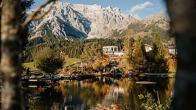 herbsturlaub-uebergossene-alm-resort-salzburg-001 Ansicht des Hotels mit Almsee in Herbststimmung