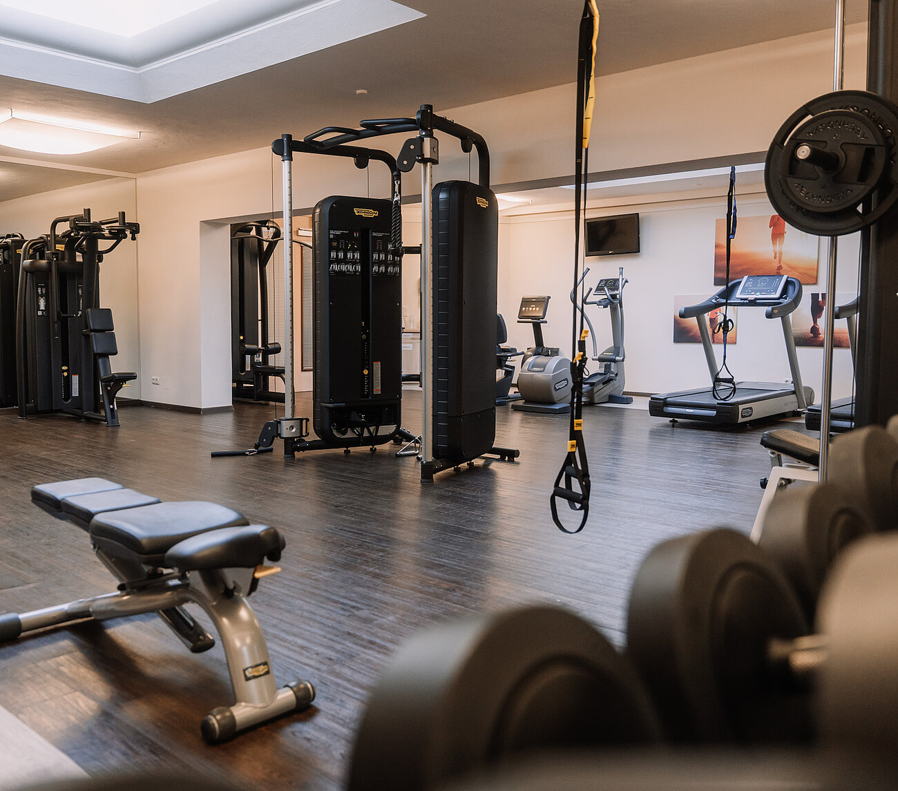 Moderner Fitnessraum mit Geräten von Technogym und funktionalem Trainingsbereich