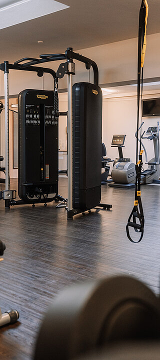 Moderner Fitnessraum mit Geräten von Technogym und funktionalem Trainingsbereich