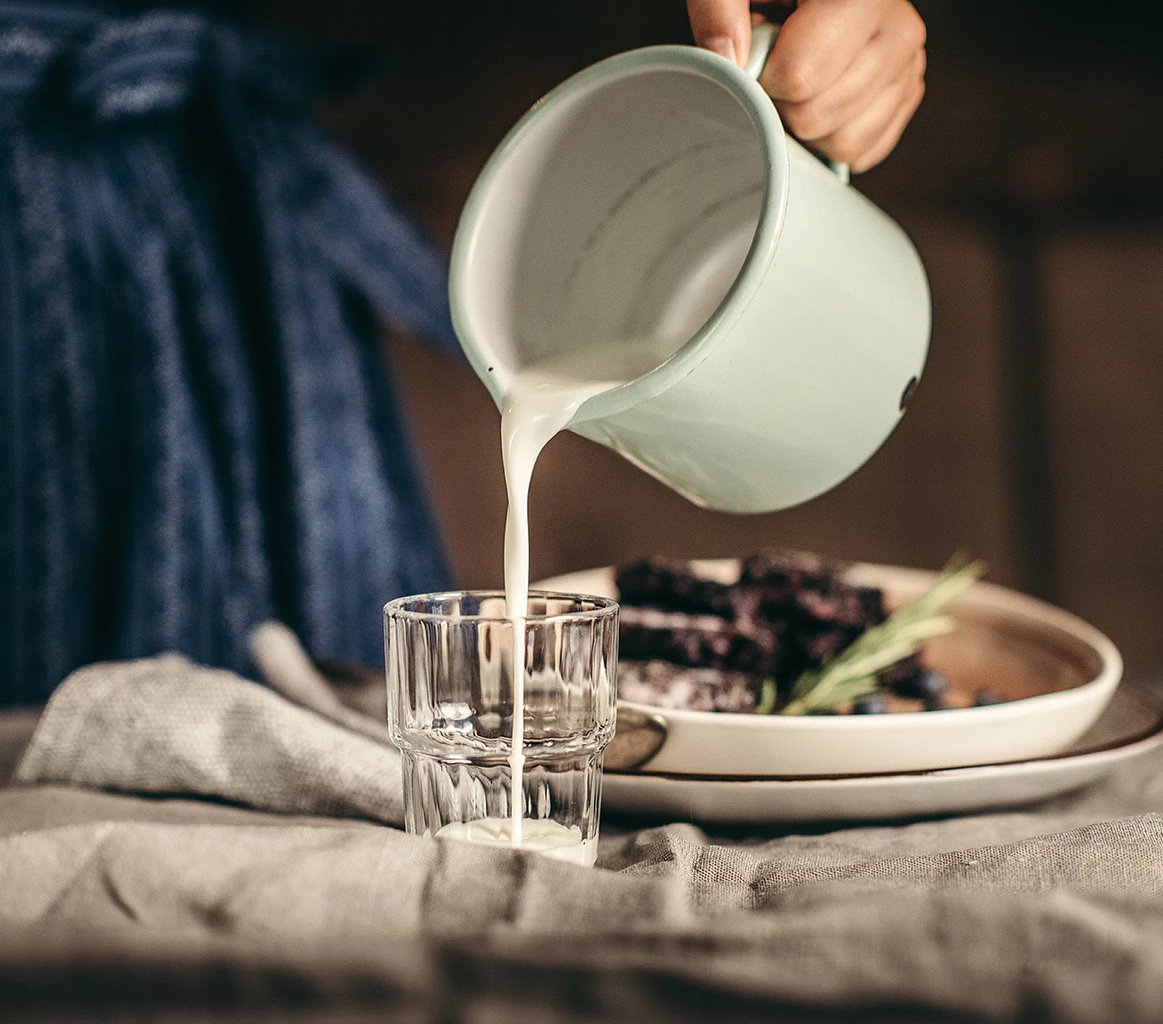 Übergossene Alm - Kellnerin schenkt Milch in Glas ein