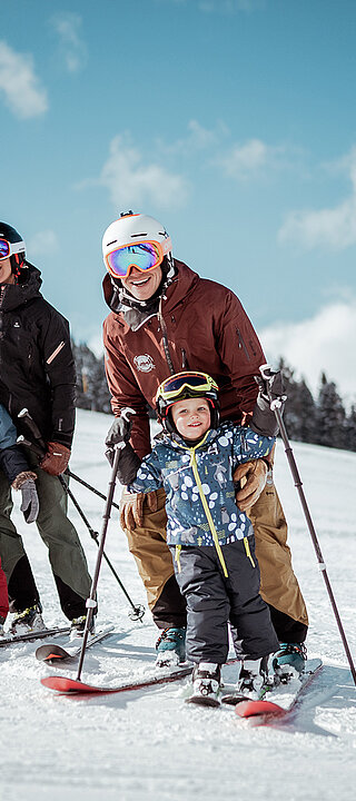 Die ganze Familie beim Skifahren auf der Piste direkt am Hotel Übergossene Alm.