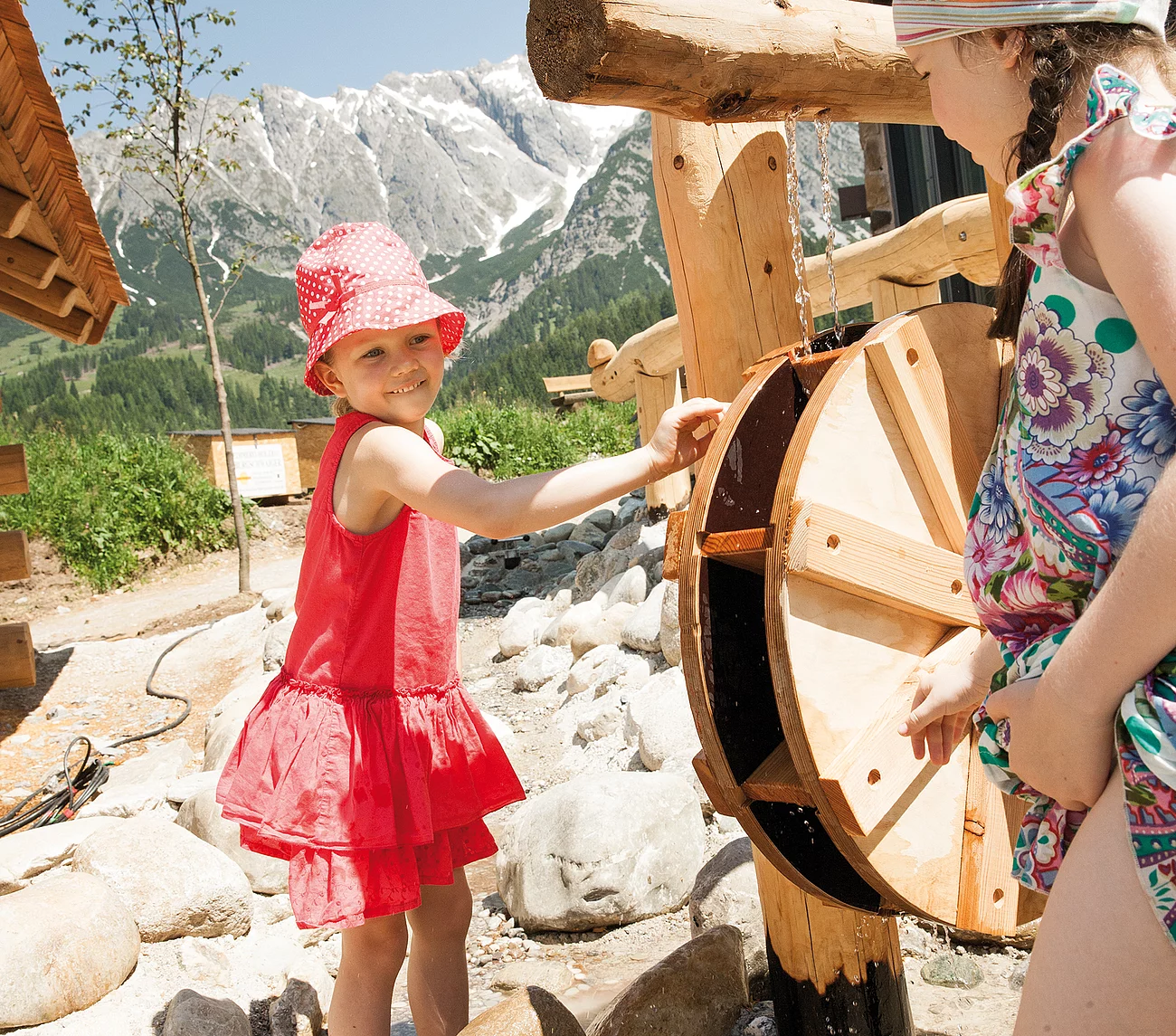 Übergossene Alm - Kind beim Wasser spielen am Almspielplatz