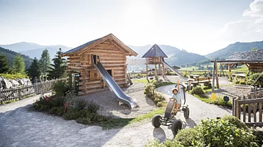 Übergossene Alm - Kind beim Go-Card fahren durch den Almspielplatz