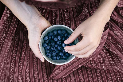 Übergossene Alm - Frau mit Schale voller Blaubeeren
