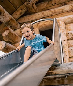 Übergossene Alm - Outdoor Almspielplatz Kind beim Rutschen