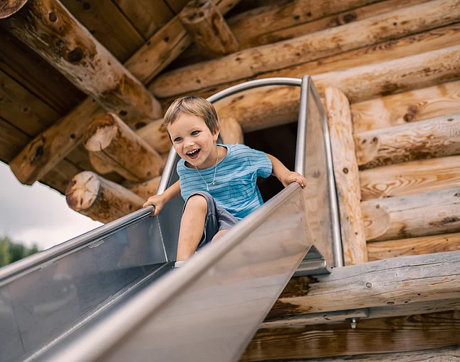 Übergossene Alm - Outdoor Almspielplatz Kind beim Rutschen